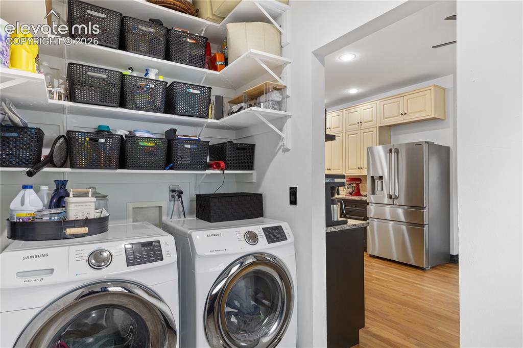 Image 27 of 45: Dedicated laundry area featuring front-loading machines and extensive built