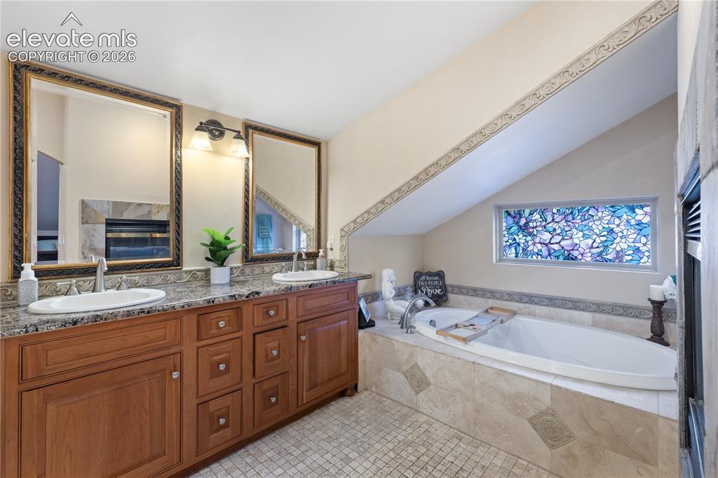 Image 33 of 45: Bathroom featuring a dual vanity with granite countertops, undermount sinks
