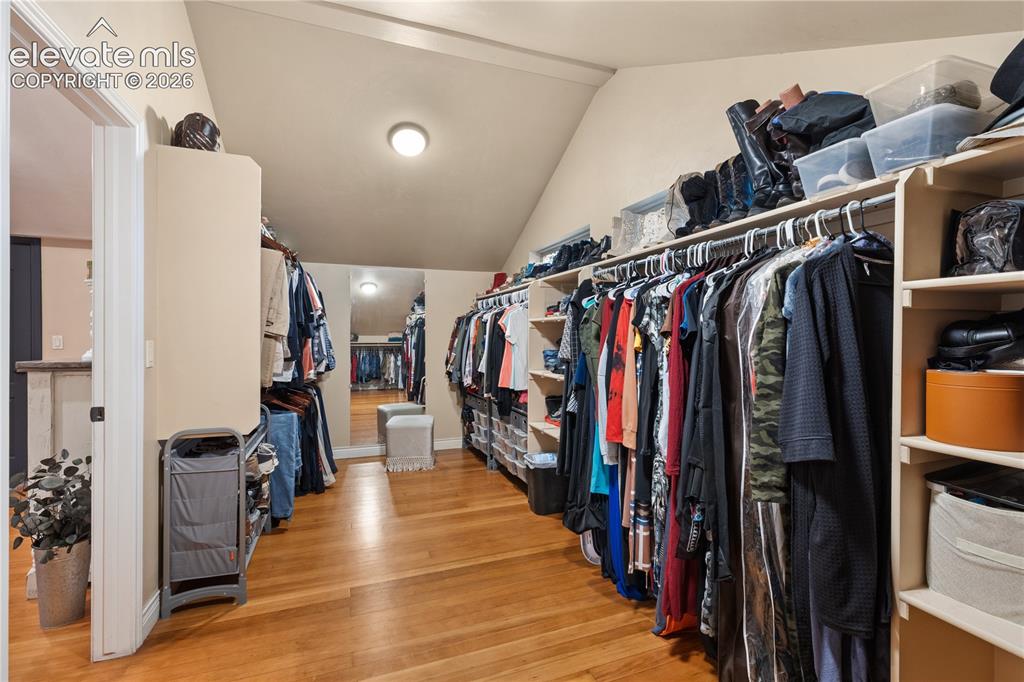 Image 34 of 45: Spacious closet featuring wood-finish flooring, sloped ceiling, recessed li