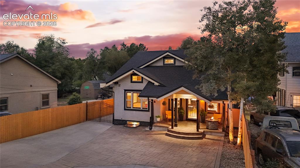 Image 4 of 45: Craftsman-style exterior featuring a covered front porch with dark wood col