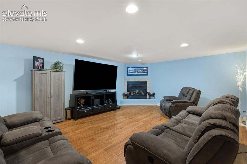 Image 40 of 45: Spacious entertainment area featuring wood-finish flooring and light blue w
