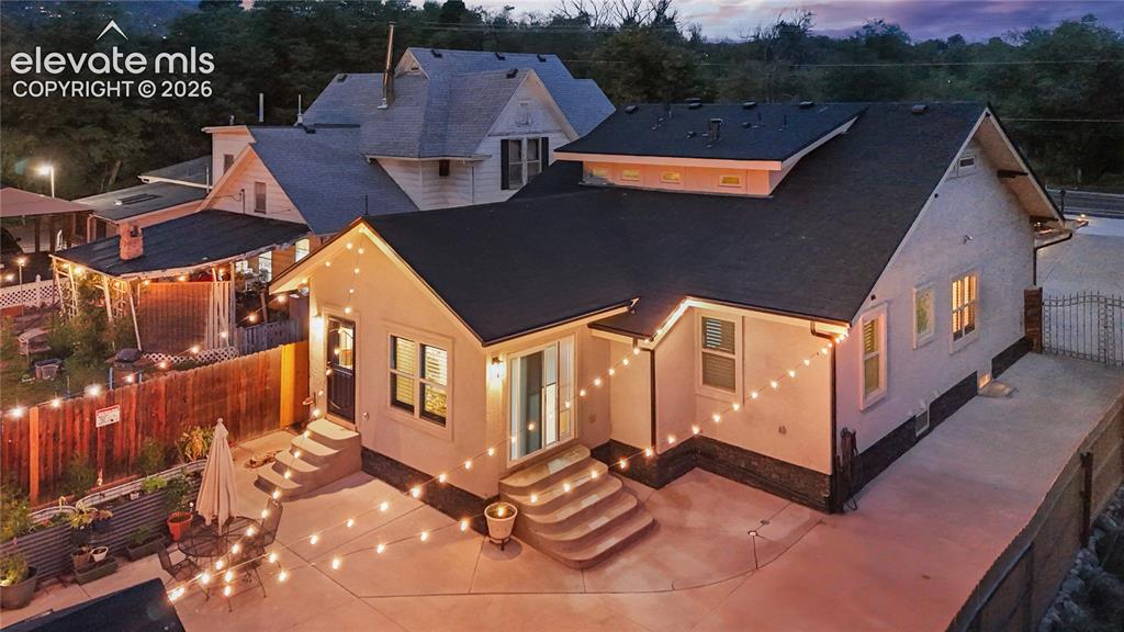 Image 8 of 45: Exterior featuring stucco siding, a dark shingle roof, and multiple window 