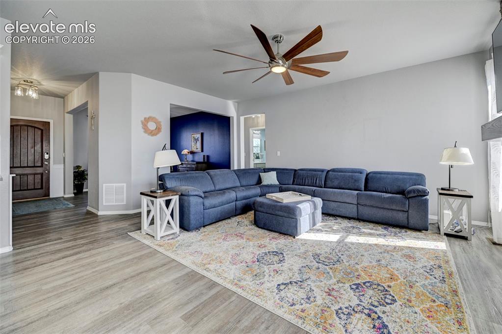 Image 13 of 48: Spacious living area featuring wood-finish flooring, a contemporary ceiling