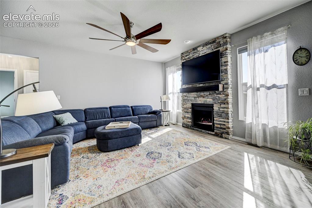 Image 14 of 48: Living area featuring a floor-to-ceiling stacked stone fireplace with an in