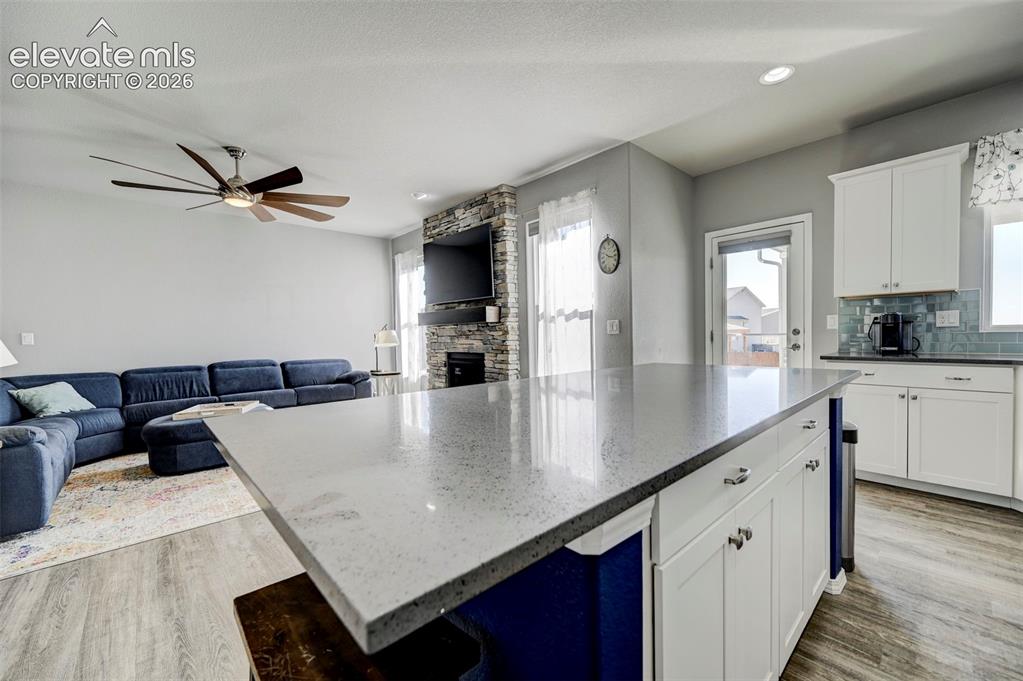 Image 15 of 48: Kitchen island featuring a speckled countertop and white shaker-style cabin