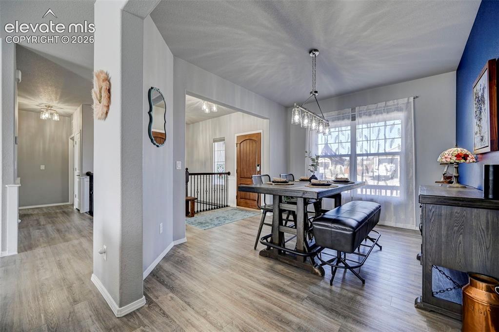 Image 18 of 48: Open-concept dining area featuring wood-finish flooring, a contemporary lin
