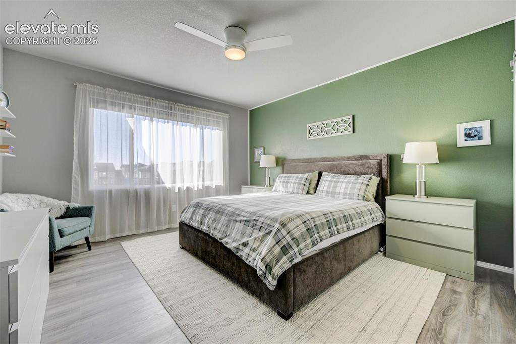 Image 20 of 48: Spacious room featuring wood-finish flooring, a contemporary ceiling fan wi
