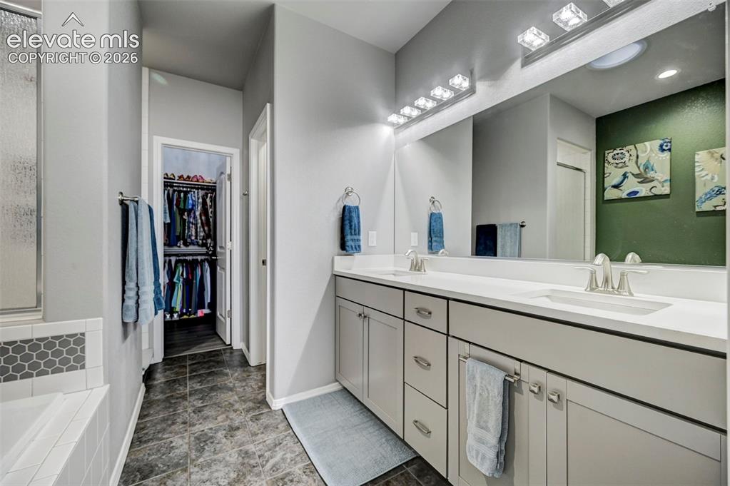 Image 23 of 48: Dual vanity with light gray cabinetry, brushed nickel hardware, and white c