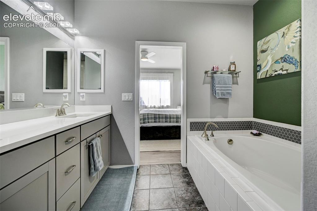 Image 24 of 48: Bathroom featuring a white built-in bathtub with subway tile surround and a