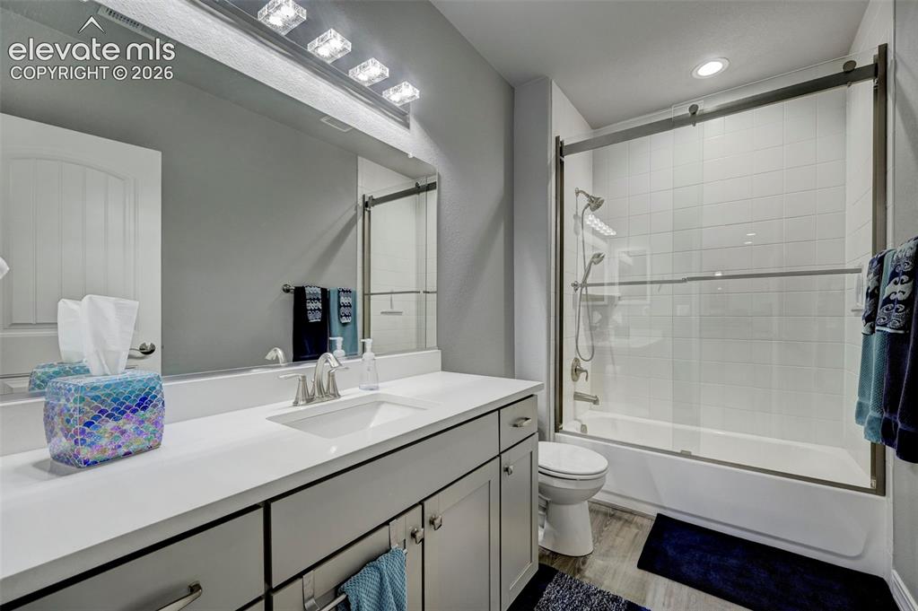Image 29 of 48: Bathroom featuring a vanity with an integrated sink, a large mirror, and a