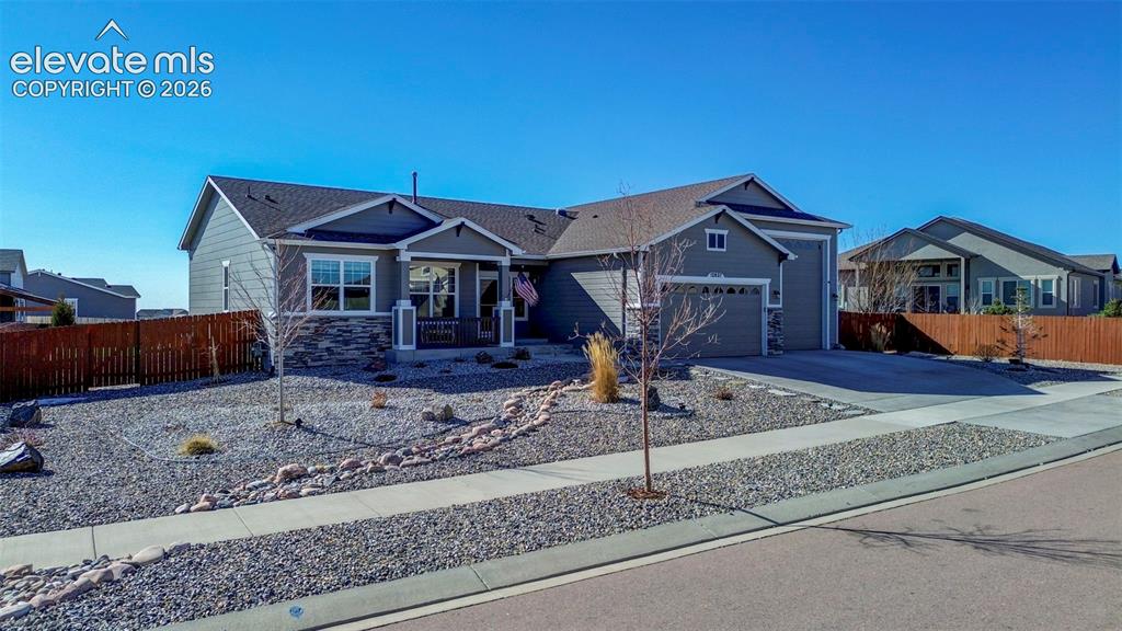 Image 3 of 48: Ranch-style exterior featuring gray siding, stone accents, and a covered fr
