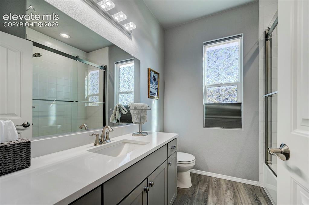 Image 43 of 48: Bathroom featuring a spacious vanity with an undermount sink and a white co