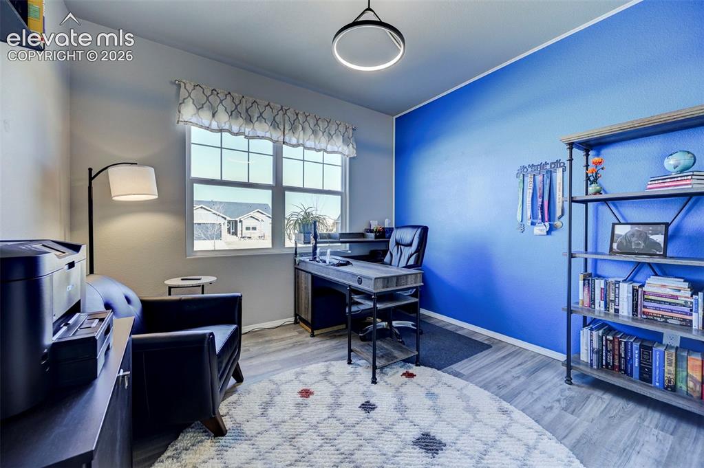 Image 45 of 48: Bright interior room featuring a large window with gridded panes, light woo