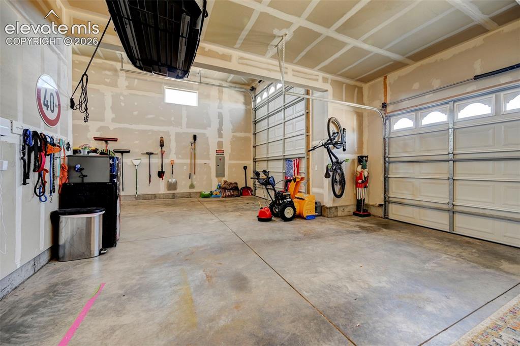 Image 46 of 48: Spacious garage featuring concrete flooring and two overhead garage doors
