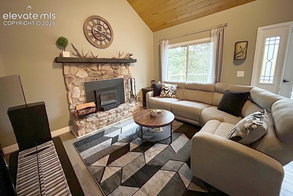 Image 13 of 32: Family room featuring vaulted wood-finish ceiling, beautiful stone fireplac