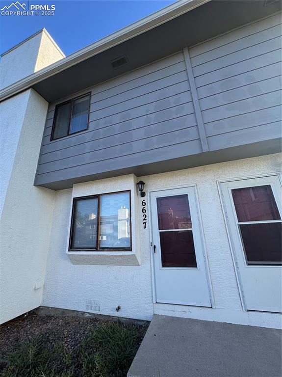 Caption: View of front facade with stucco siding