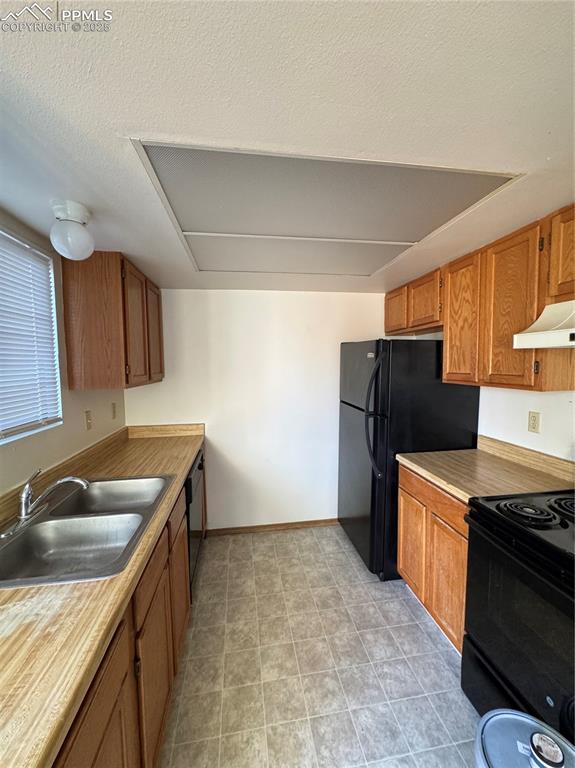 Image 4 of 11: Kitchen with range, refrigerator, light countertops, ventilation hood, and 