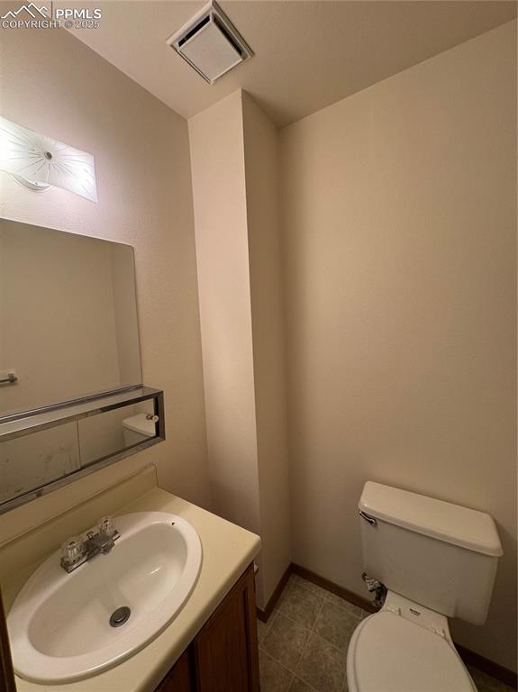 Image 5 of 11: Bathroom with vanity and dark tile patterned floors