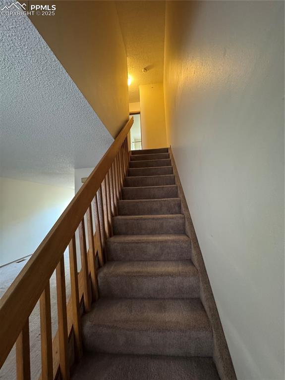 Image 6 of 11: Stairway with a textured ceiling