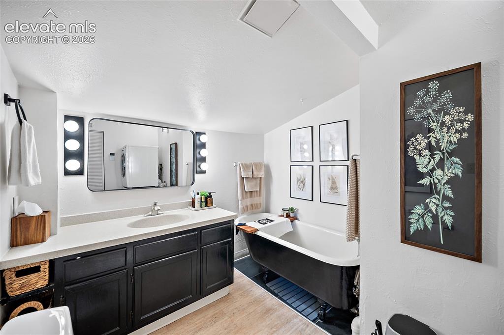 Image 12 of 31: Stylish bathroom featuring a striking black clawfoot soaking tub, modern bl