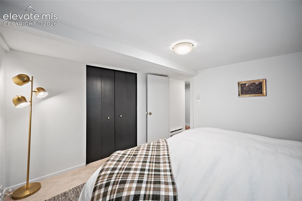 Image 16 of 31: Restful bedroom featuring bold black bi-fold closet doors, fresh white wal