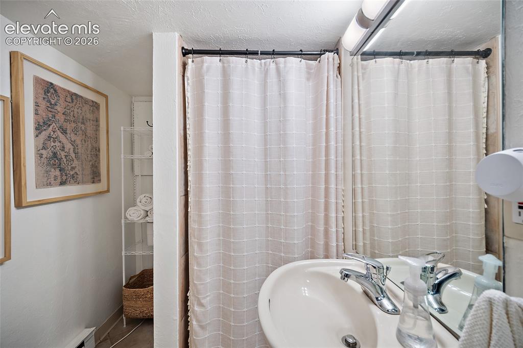 Image 17 of 31: Clean, bright bathroom with a walk-in shower, pedestal sink, and tasteful f