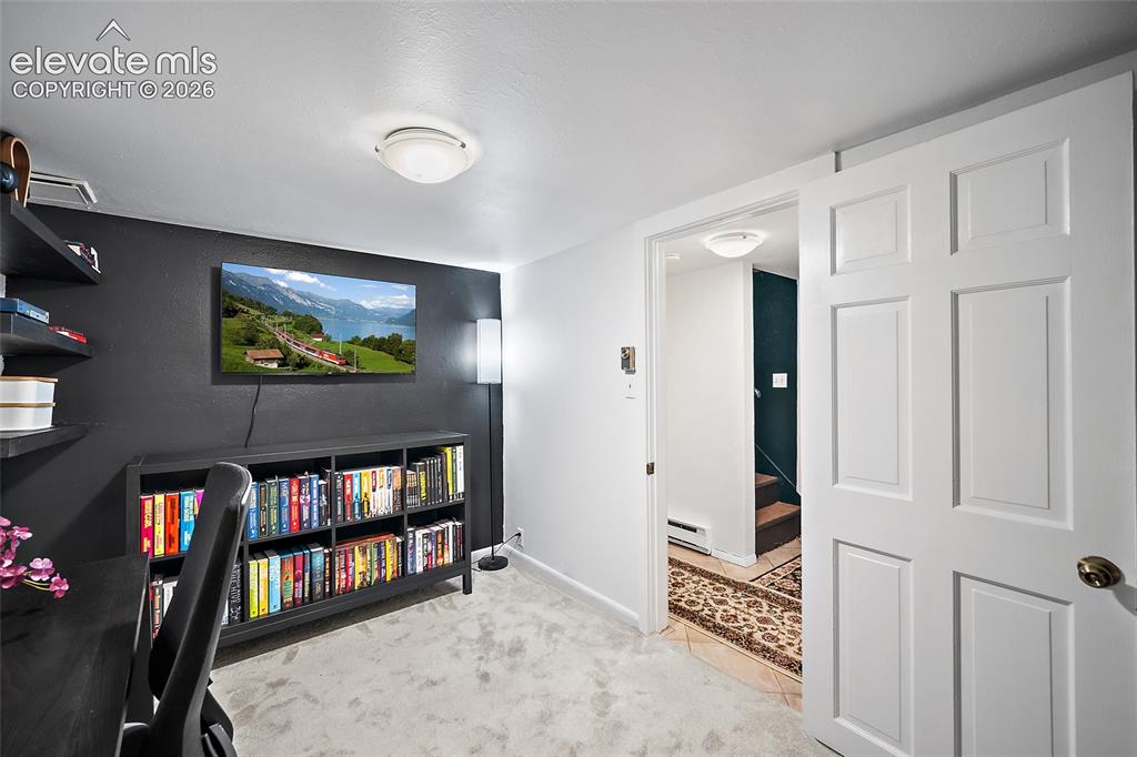 Image 19 of 31: Flexible bonus room with crisp white walls, a dramatic dark accent wall, a