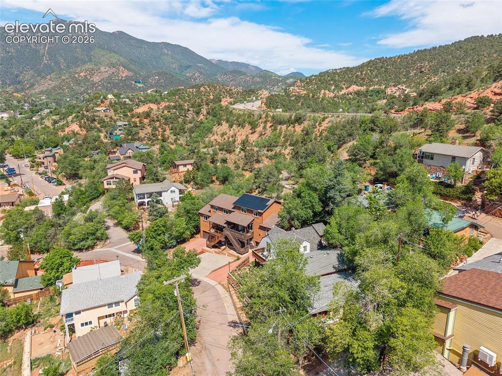 Image 25 of 31: Stunning aerial showcasing the home nestled among the foothills, with drama