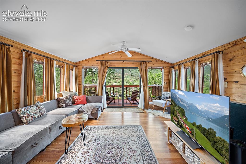 Image 3 of 31: Sun-drenched living space framed by abundant windows and cedar-tongue-and-g