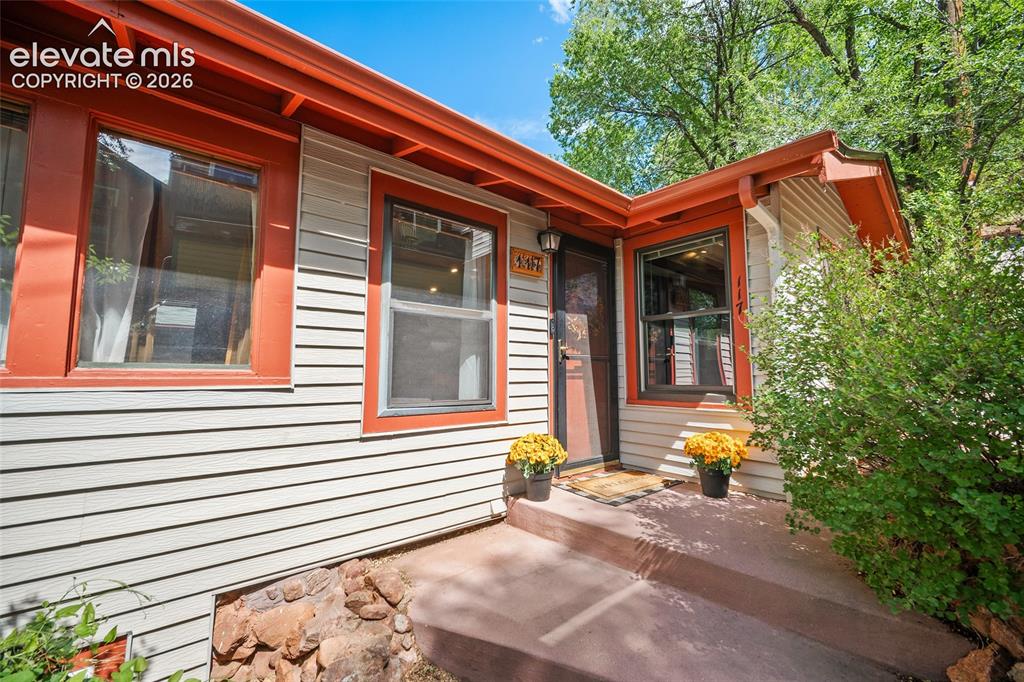 Image 4 of 31: Inviting front entrance showcasing crisp light-gray lap siding paired with