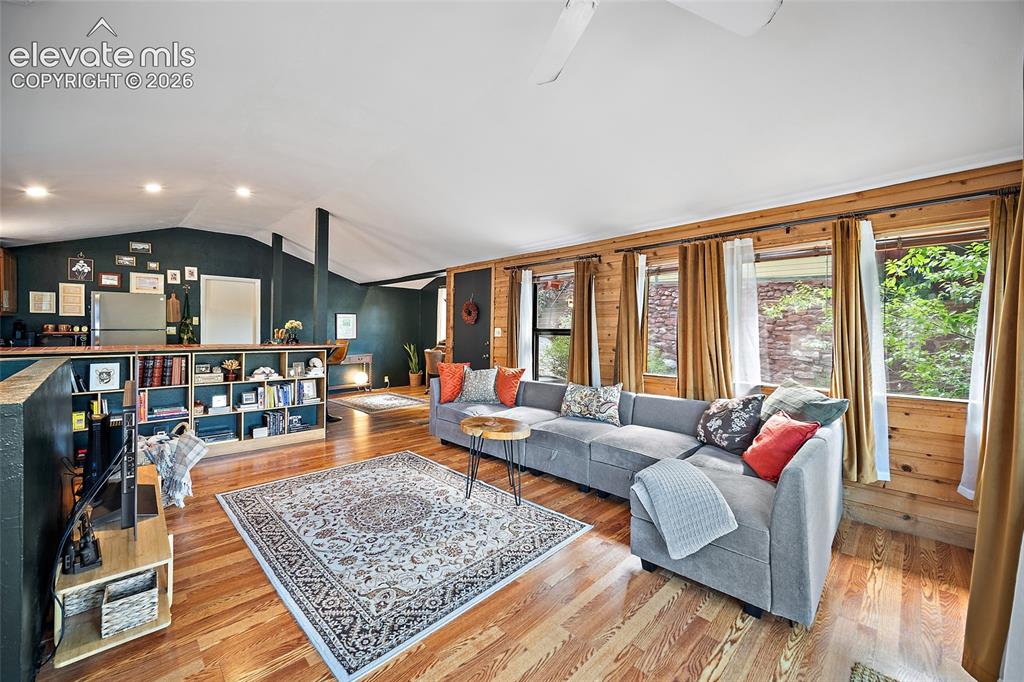 Image 6 of 31: Spacious great room blending modern and rustic style, with a deep forest-gr