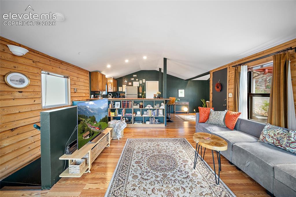 Image 7 of 31: Flowing open floor plan connecting the living area, built-in library shelvi