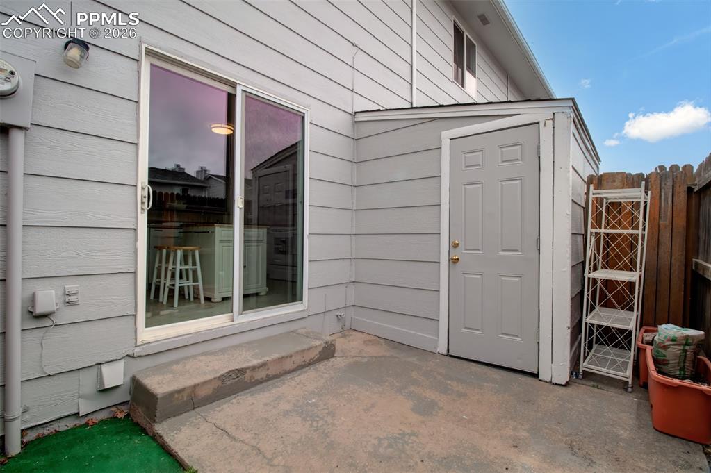 Image 12 of 20: Sliding glass door opens to a patio and a storage shed