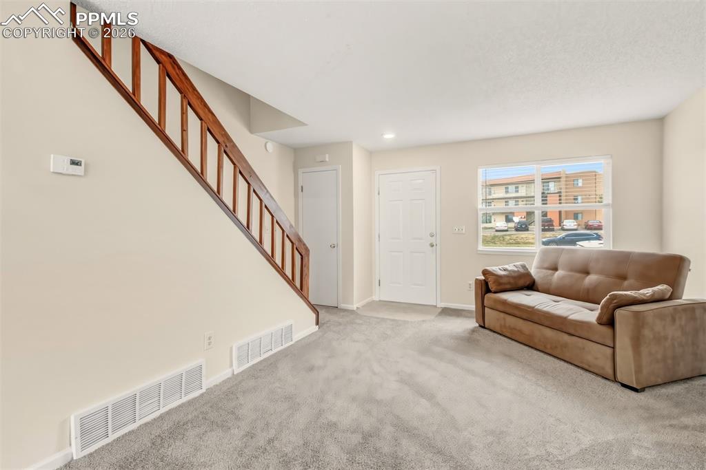 Image 4 of 20: Living room with new carpet and a comfy couch