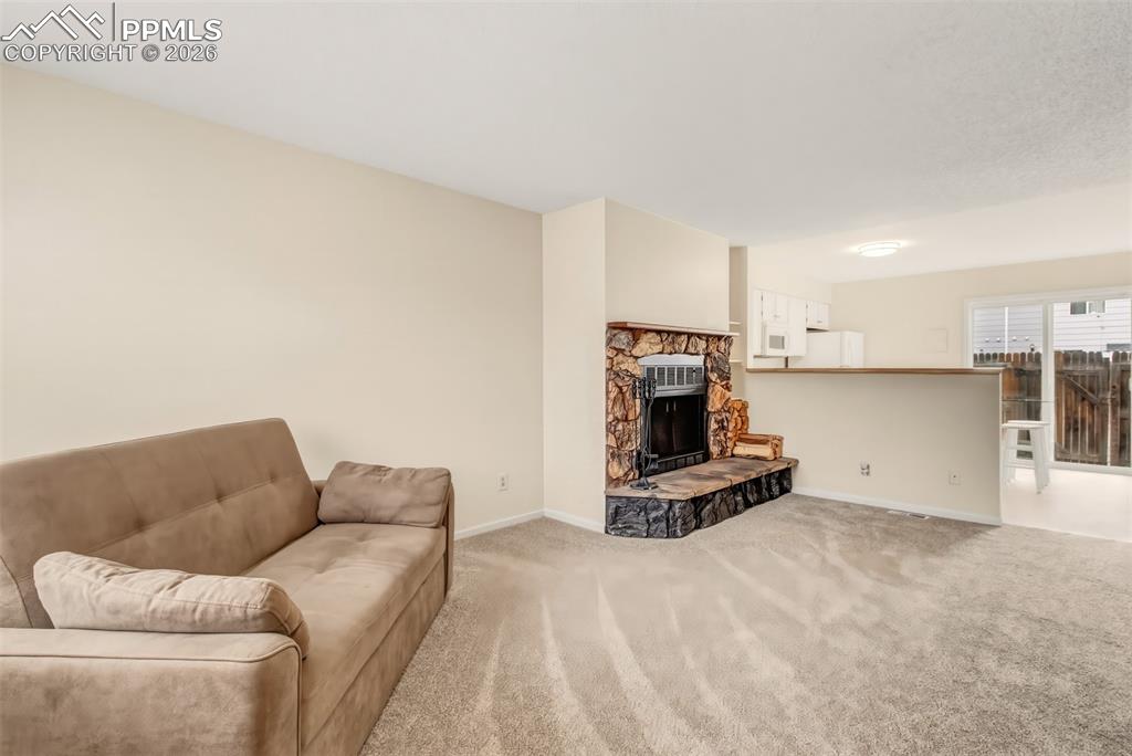 Image 5 of 20: The living room has a wood burning fireplace