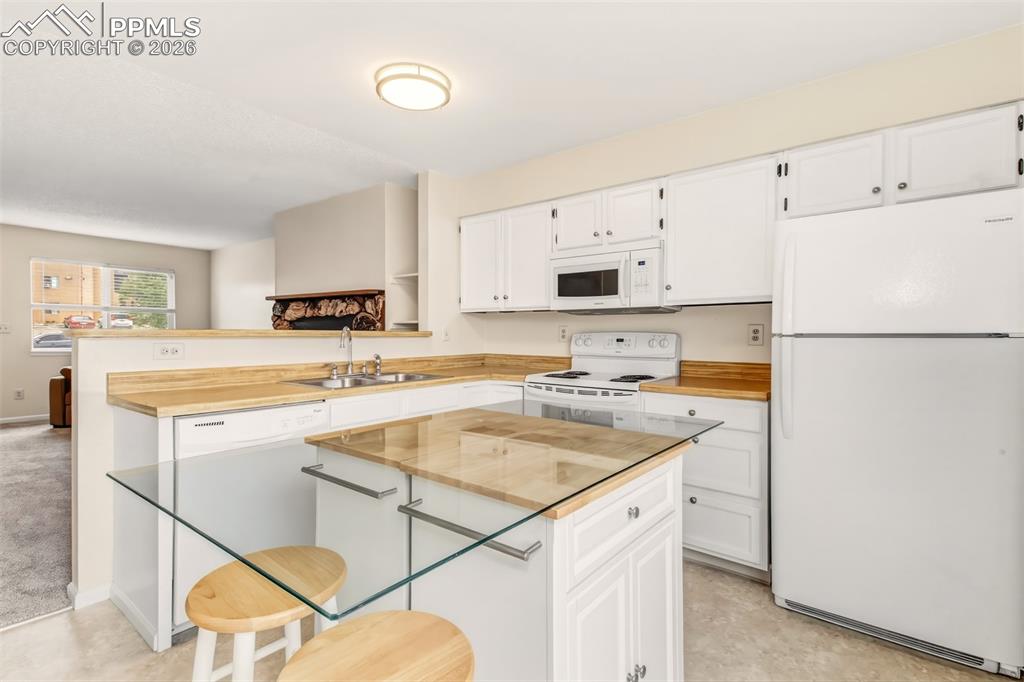 Image 8 of 20: Kitchen features a breakfast bar and an island