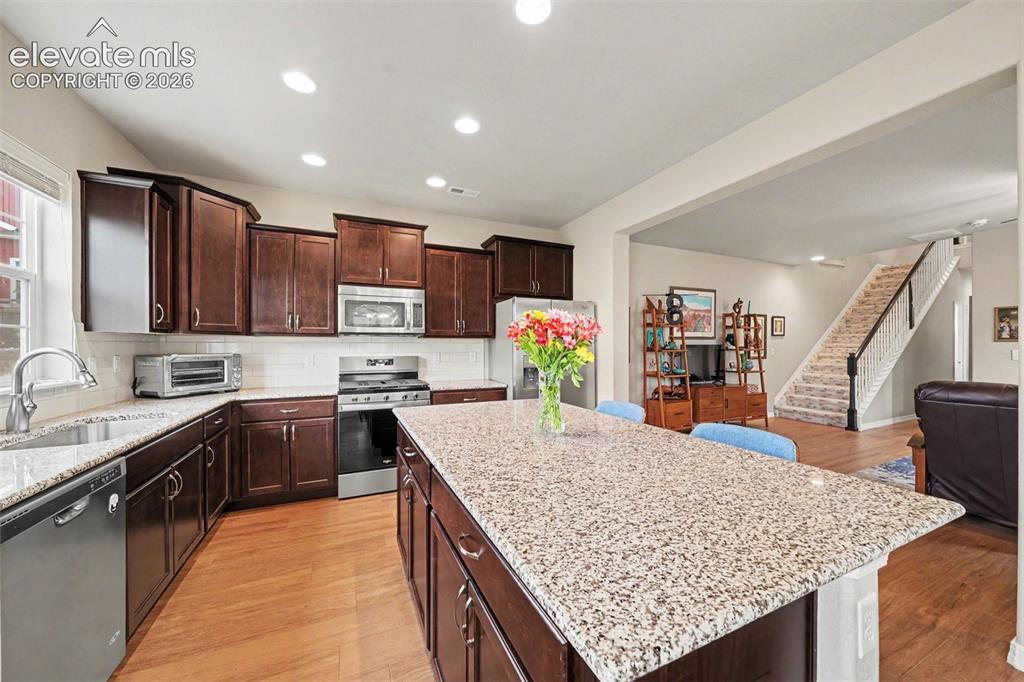 Image 10 of 26: Another view of kitchen from dining area - great open floor plan on main le