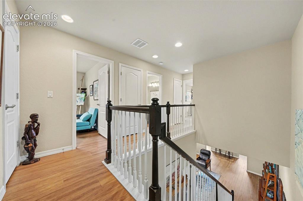 Image 15 of 26: Upper level hall leading to two additional bedrooms and a full bath