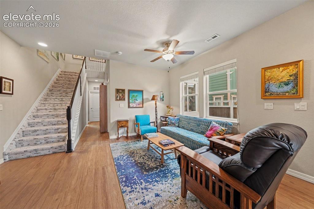 Image 6 of 26: Living area with beautiful staircase leading to upper level and hallway lea