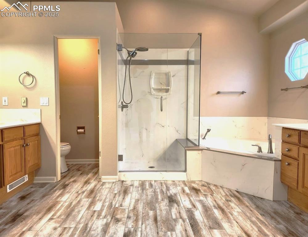 Image 13 of 34: Full bathroom with vanity, a marble finish shower, a bath, and wood finishe