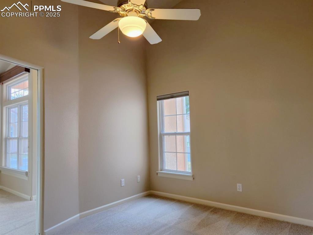 Image 22 of 34: Spare room with light colored carpet, ceiling fan, and a towering ceiling