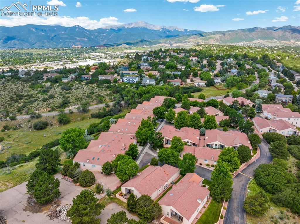 Image 27 of 34: Aerial view of residential area featuring a mountainous background