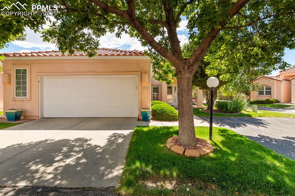Image 3 of 34: Mediterranean / spanish house with a tile roof, driveway, stucco siding, an