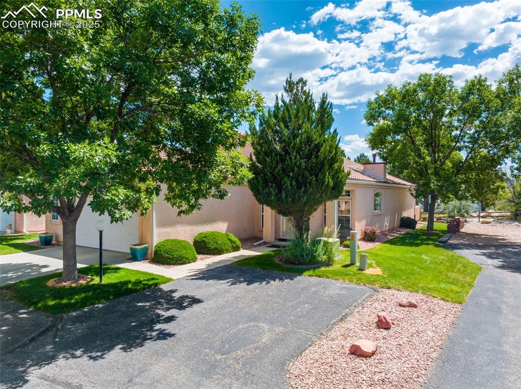 Image 30 of 34: Obstructed view of property with concrete driveway, stucco siding, a front