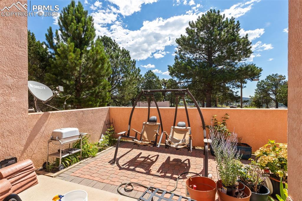 Image 31 of 34: Fenced backyard with a patio area and grilling area