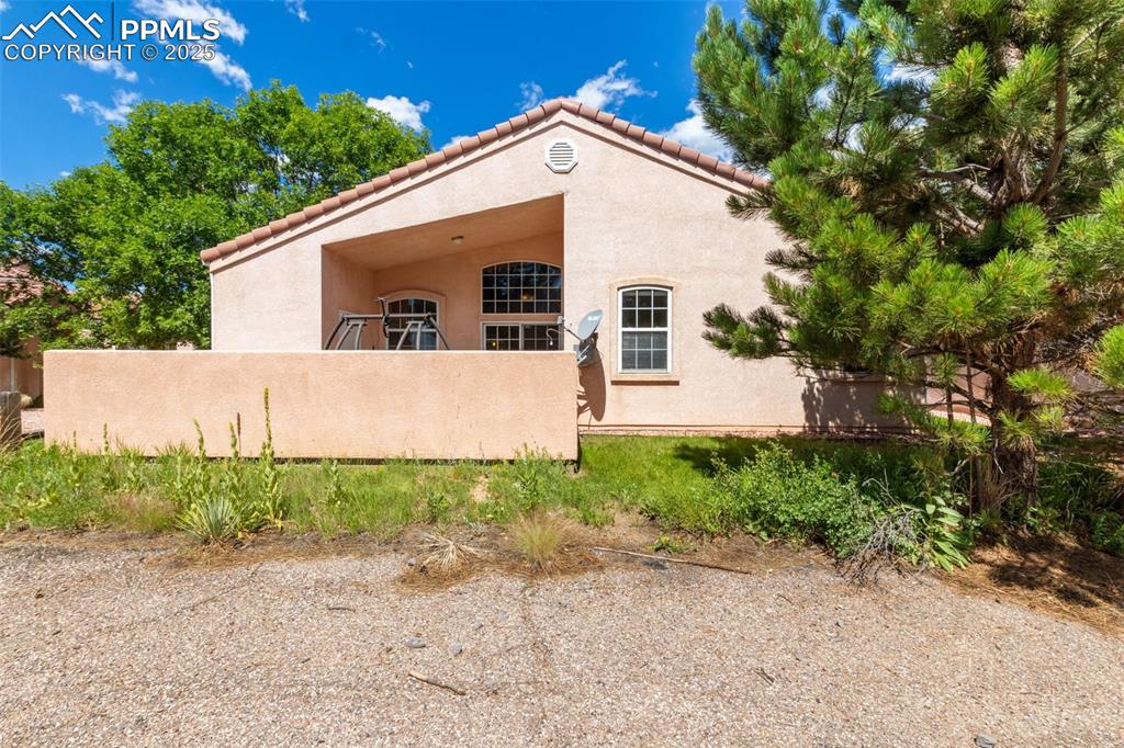 Image 34 of 34: View of side of home with stucco siding and a tiled roof