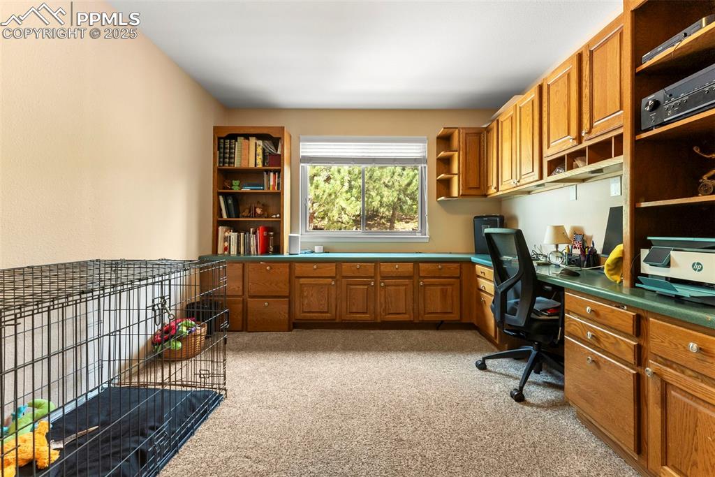 Image 13 of 50: Office area featuring light colored carpet and built in desk