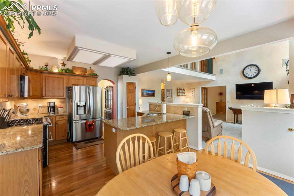 Image 20 of 50: Dining area with arched walkways and dark wood-type flooring