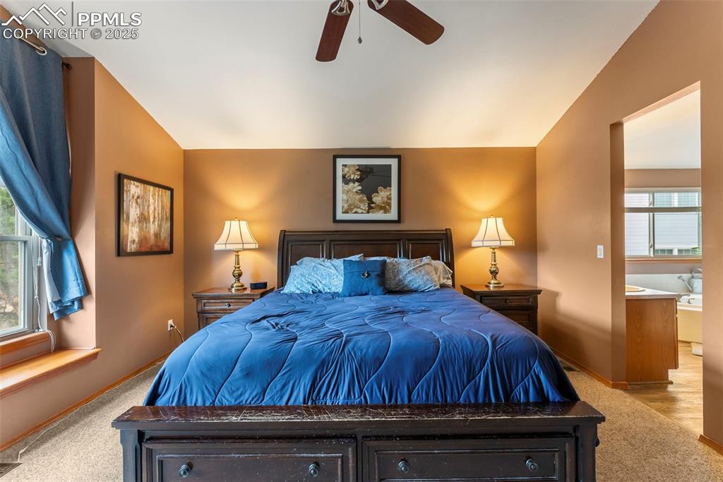 Image 27 of 50: Carpeted bedroom featuring vaulted ceiling and a ceiling fan