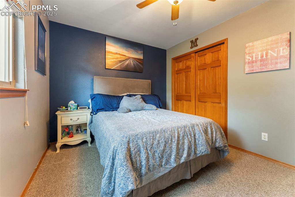 Image 31 of 50: Carpeted bedroom with a closet and ceiling fan